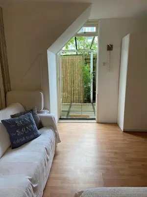 a living room with a couch and a sliding glass door at Gartenblick in Zandvoort