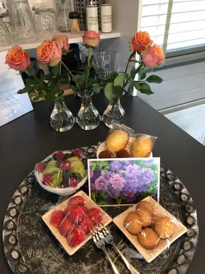 a table topped with a plate of food and flowers at Tiny House Boatshed in Heemstede