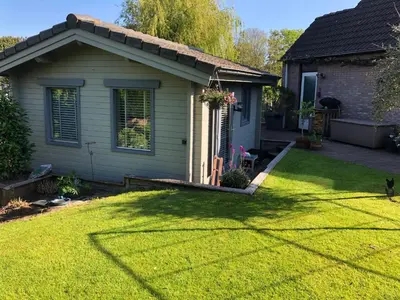 a backyard with a house and a yard withgrass at Tiny House Boatshed in Heemstede