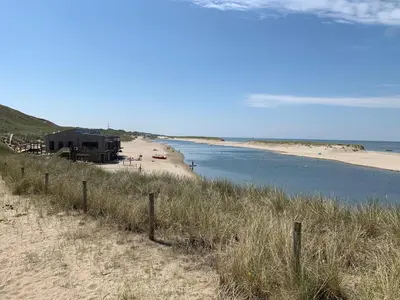 a view of a beach with a house on it at Vogelvrij, vakantie woning met landelijk uitzicht en geheel omheinde tuin in Burgerbrug