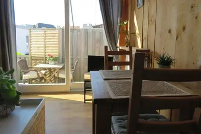a dining room with a table and chairs and a balcony at Beachtime close to the beach, city centre in Zandvoort