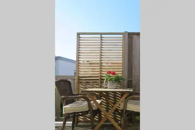 a table and chairs with a flower on a balcony at Beachtime close to the beach, city centre in Zandvoort