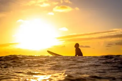 a person sitting on a surfboard in the ocean at Beachtime close to the beach, city centre in Zandvoort