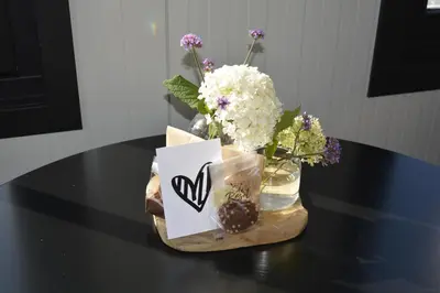 a table with a vase of flowers and a sign at Woudmeer 1 in Dirkshorn