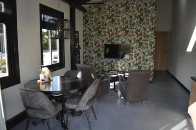 a dining room with a table and chairs and a tv at Woudmeer 1 in Dirkshorn