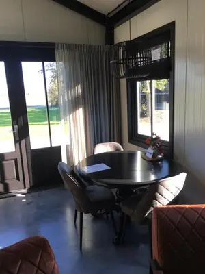 a dining room with a black table and chairs at Woudmeer 1 in Dirkshorn