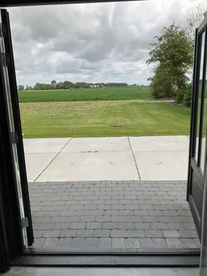 an open door with a view of a field at Woudmeer 1 in Dirkshorn