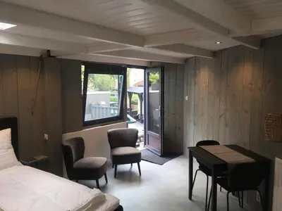 a bedroom with a bed and a table and chairs at Centre beach lodge (2) in Zandvoort