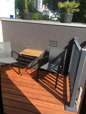 a wooden table and chairs on a balcony with a table at Centre beach lodge (2) in Zandvoort