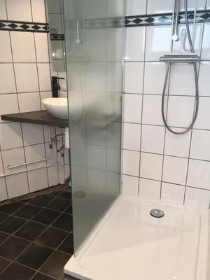 a shower with a glass door in a bathroom at Centre beach lodge (2) in Zandvoort