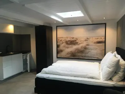 a bedroom with a bed with a painting on the wall at Centre beach lodge (2) in Zandvoort