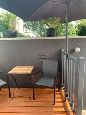 a table and a chair and an umbrella on a porch at Centre beach lodge (2) in Zandvoort