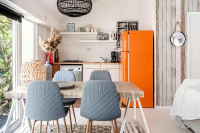 a kitchen with a table and chairs and an orange refrigerator at Hippie Beach in Zandvoort