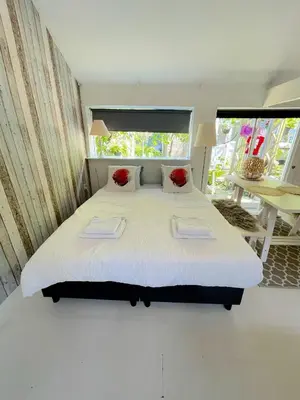 a bedroom with a large bed with two red pillows at Hippie Beach in Zandvoort
