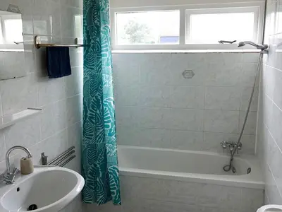 a bathroom with a bath tub and a sink at Family Escape Near Keukenhof in Noordwijkerhout