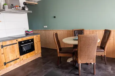 a kitchen with a table and chairs and a stove at 4T4 Apartment B in Egmond aan den Hoef