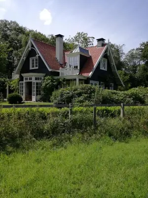 a black house with a red roof at Huize Koempoelan in Naarden