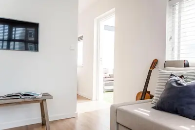 a living room with a couch and a guitar at The Shell Apartment in Zandvoort
