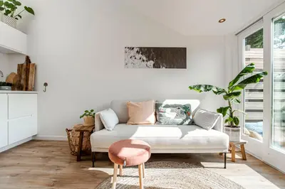 a living room with a white couch and a pink stool at SeatheDunes in Zandvoort