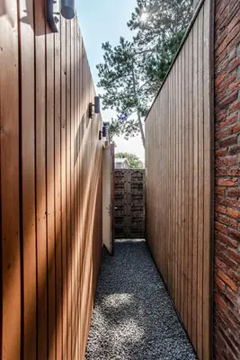 a hallway with a wooden fence and a door at SeatheDunes in Zandvoort