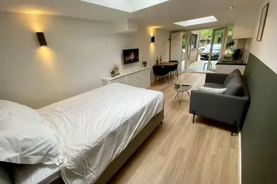 a bedroom with a bed and a couch and a living room at Stella Maris Dune Apartment in Zandvoort