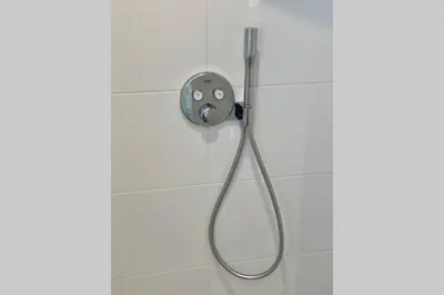 a shower with a shower head on a wall at Stella Maris Dune Apartment in Zandvoort