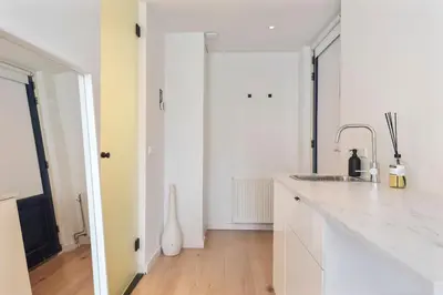 a kitchen with a white counter and a sink at Beach Studio Zen in the Centre of Zandvoort in Zandvoort