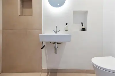 a bathroom with a white sink and a toilet at Beach Studio Zen in the Centre of Zandvoort in Zandvoort