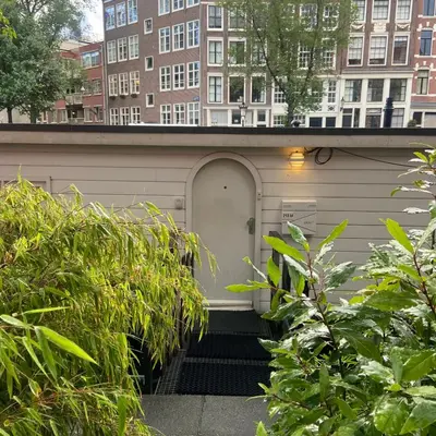 a garage with a white door and a building at Houseboat Bonnie in Amsterdam