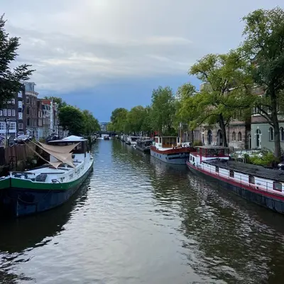 a group of boats docked on a river with buildings at Houseboat Bonnie in Amsterdam