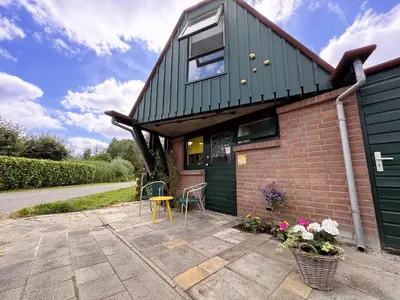 a house with a green roof and a patio at Happy Little Maya Bee in Nieuwe-Niedorp