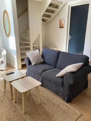 a living room with a blue couch and a table at Guesthouse Bonniehofje in Zandvoort