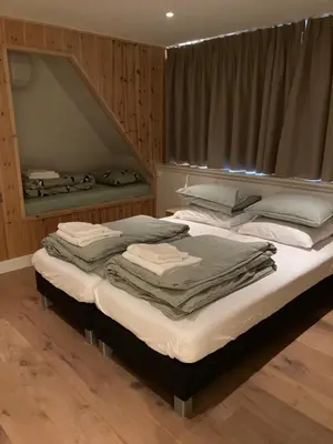 two twin beds in a room with wooden walls at Guesthouse Bonniehofje in Zandvoort
