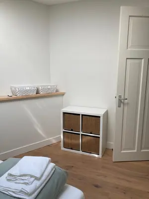 a room with a bed and a white cabinet with towels at Guesthouse Bonniehofje in Zandvoort