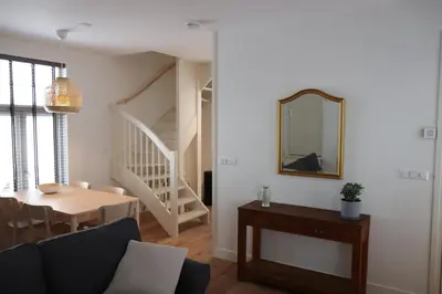 a living room with a table and a mirror at Guesthouse Bonniehofje in Zandvoort