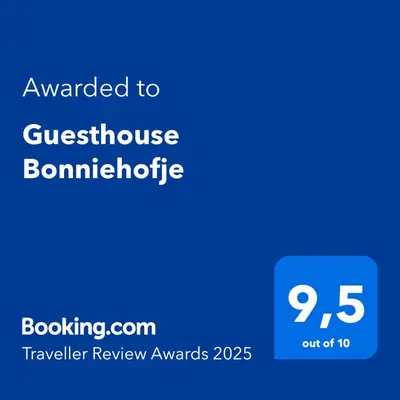 a blue sign with the text awarded to guesthouse bombardotide at Guesthouse Bonniehofje in Zandvoort