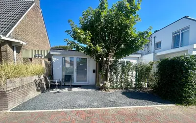 a house with a tree in the driveway at Royal Green in Zandvoort