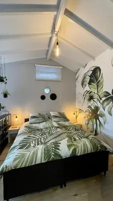 a bedroom with a bed with a plant on the wall at Royal Green in Zandvoort