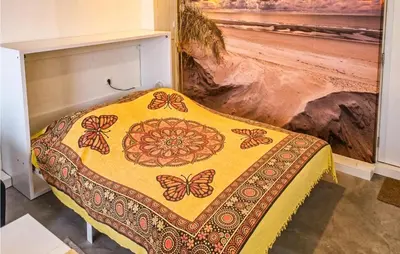 a bedroom with a bed with aspread with butterflies on it at Windwijser in Bergen aan Zee