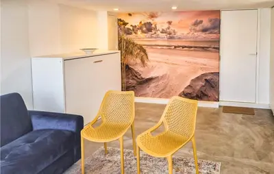 a living room with two chairs and a couch at Windwijser in Bergen aan Zee