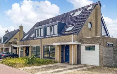 a brick house with a gambrel roof at Het Station in Bergen aan Zee