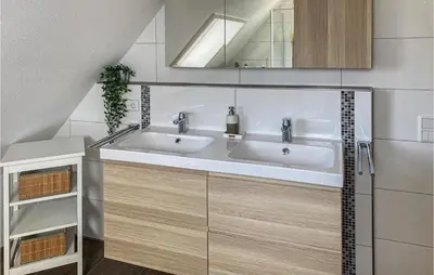 a bathroom with two sinks and a mirror at Het Station in Bergen aan Zee