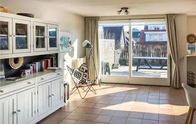 a kitchen with a door open to a patio at Het Station in Bergen aan Zee