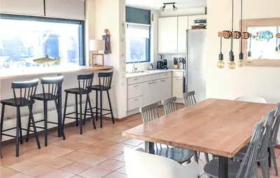 a kitchen with a wooden table and some chairs at Het Station in Bergen aan Zee