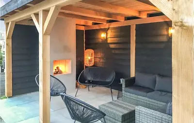 a patio with a couch and chairs and a table at Het Station in Bergen aan Zee