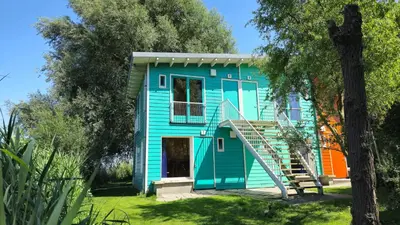 a colorful house with a staircase in a yard at Camping Zeeburg Amsterdam in Amsterdam