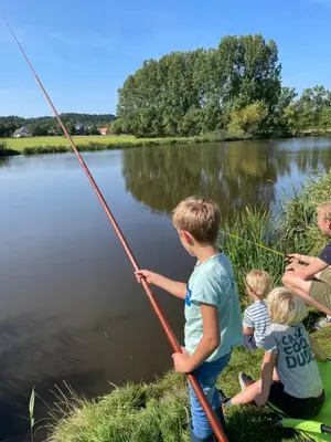 a group of children fishing on a lake at The Forester Schoorl in Schoorl