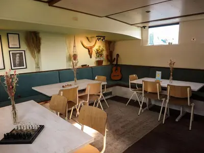 a restaurant with two tables and chairs and a guitar at FLOW in Amsterdam