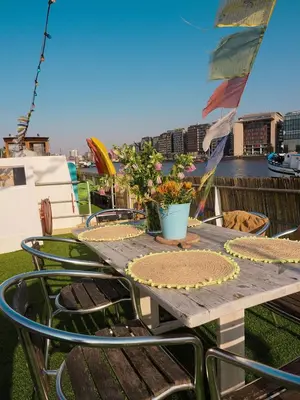 a wooden table with chairs and flowers on a balcony at FLOW in Amsterdam