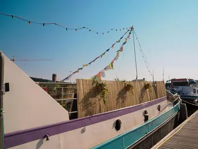 a boat tied up to a fence with flags on it at FLOW in Amsterdam